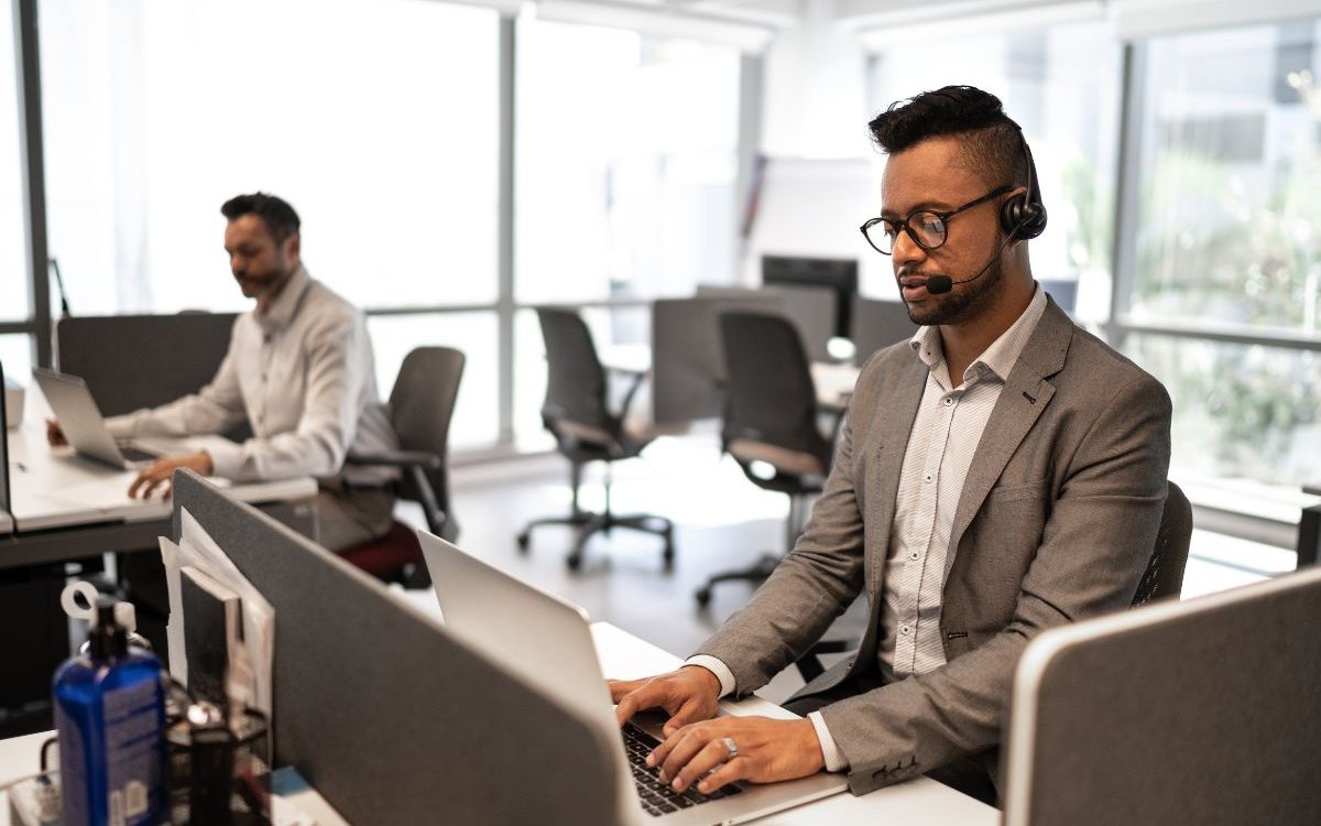 A guy taking calls in front of a laptop computer