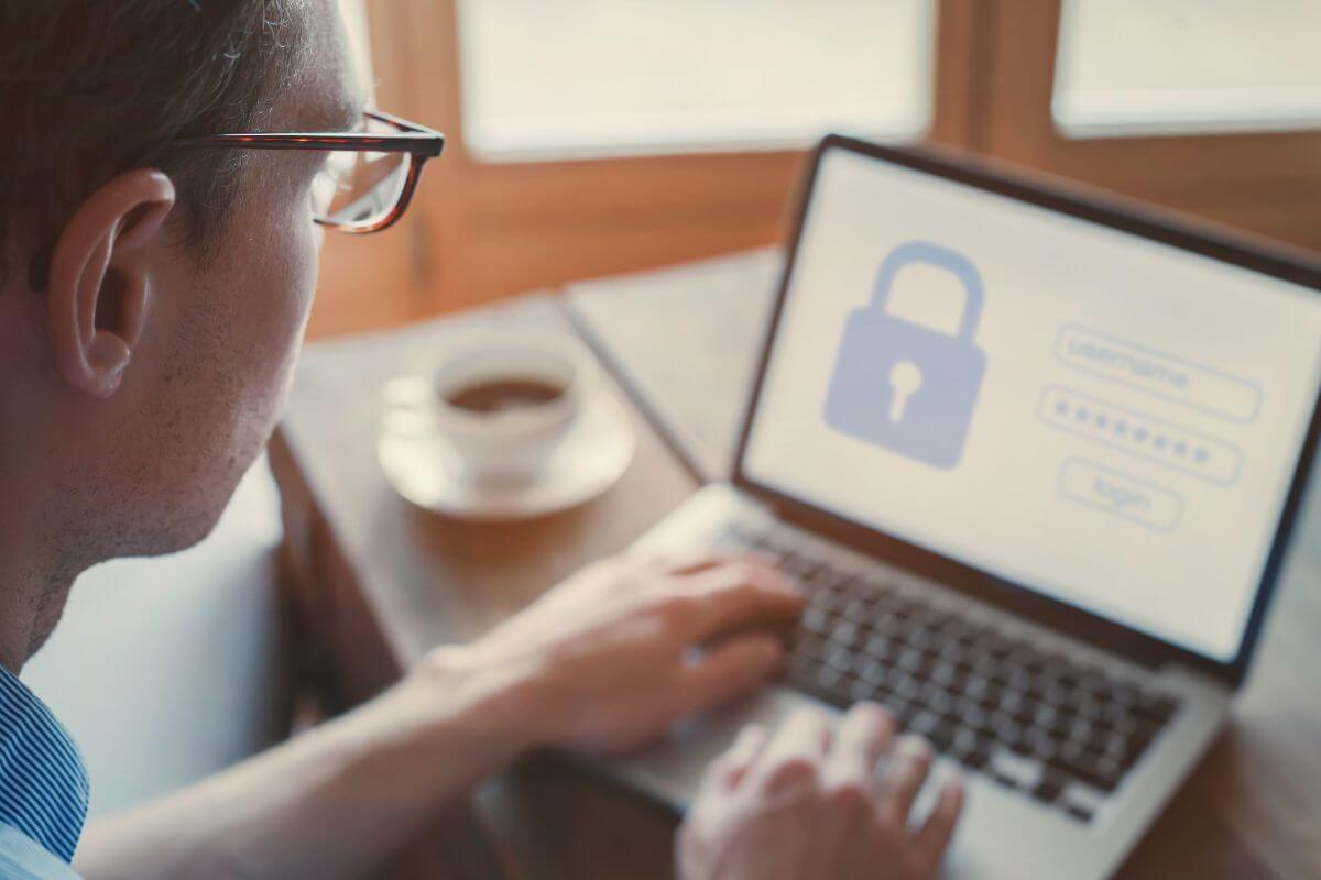 a man with glasses in front of a laptop computer doing work