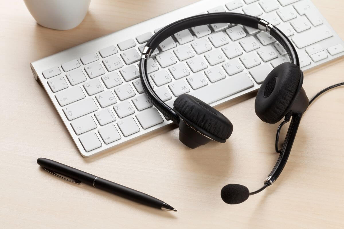 headset on top of a keyboard with a pen on the side