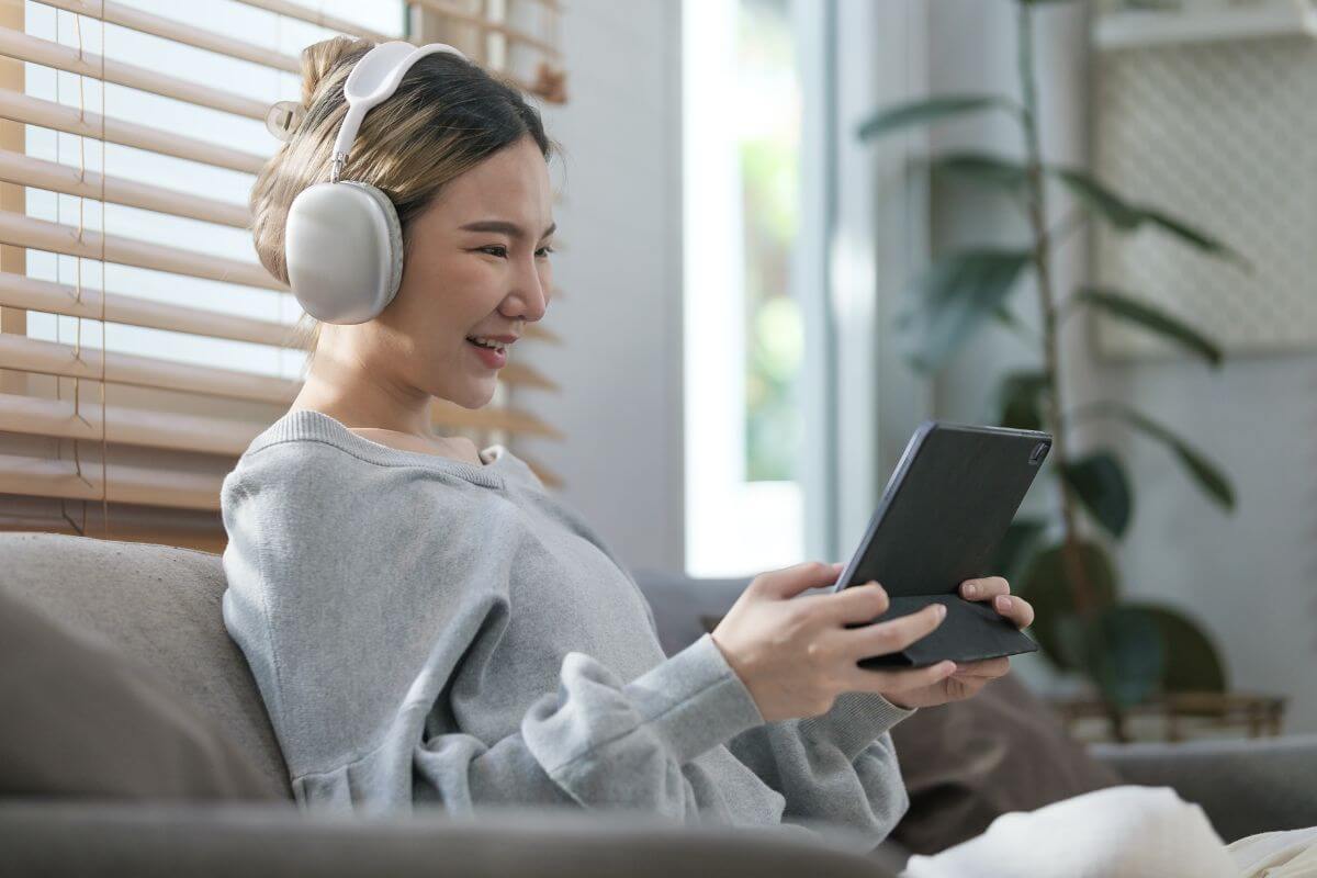 a female wearing a white headset in front of her tablet