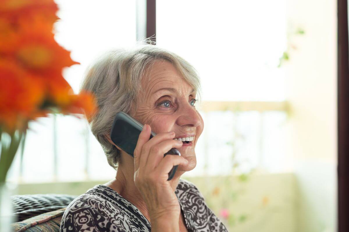 an happy old woman having a phone call